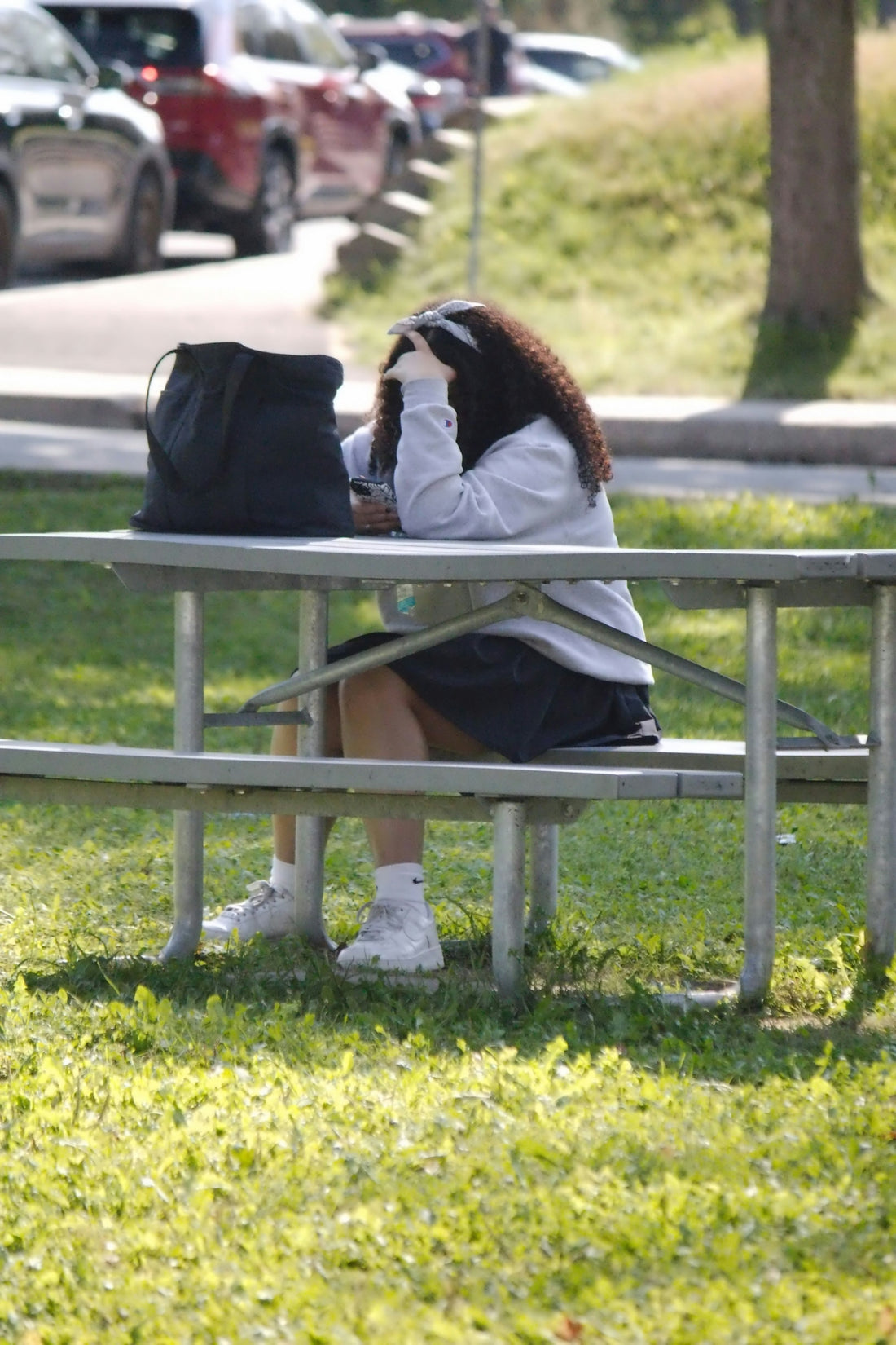 A woman sitting on a bench in a park
